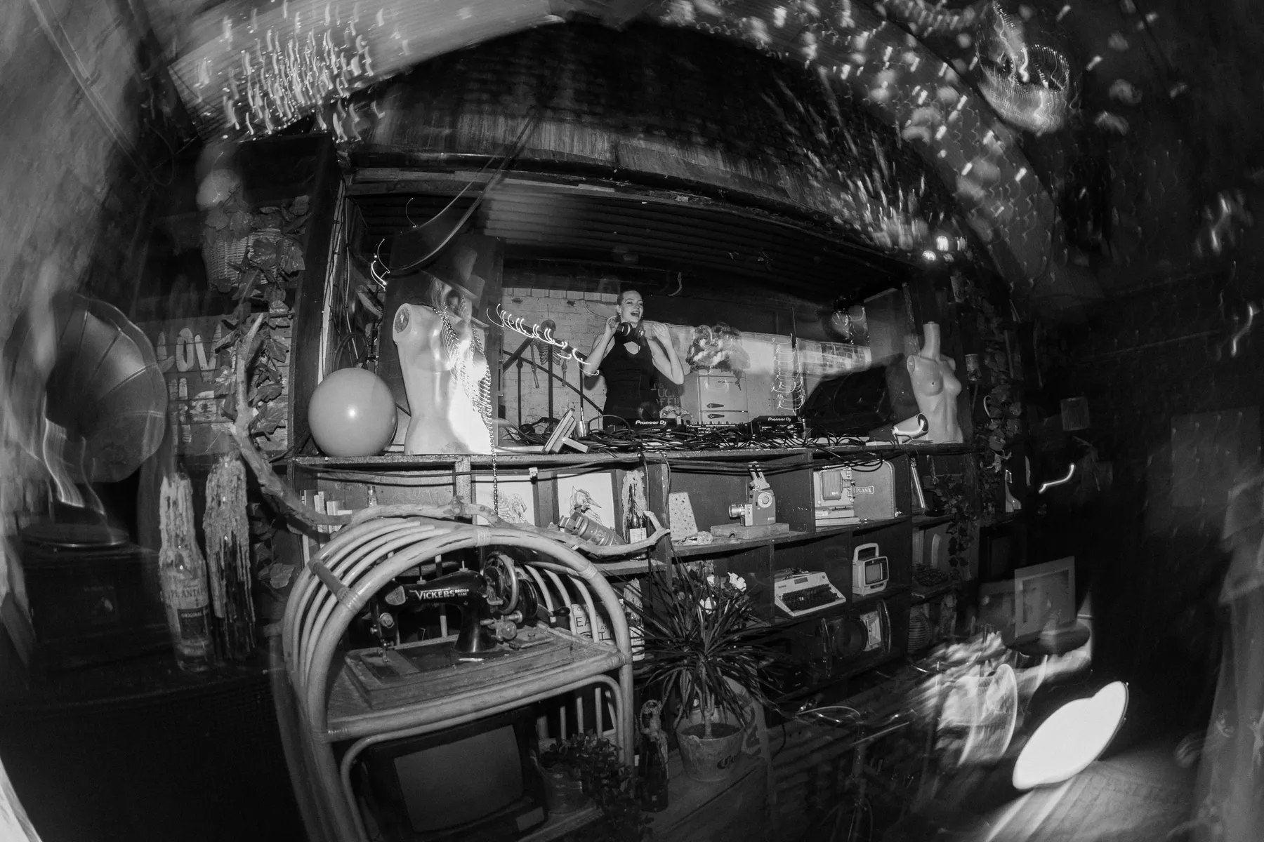 Black-and-white fisheye shot of a DJ inside The Bunker