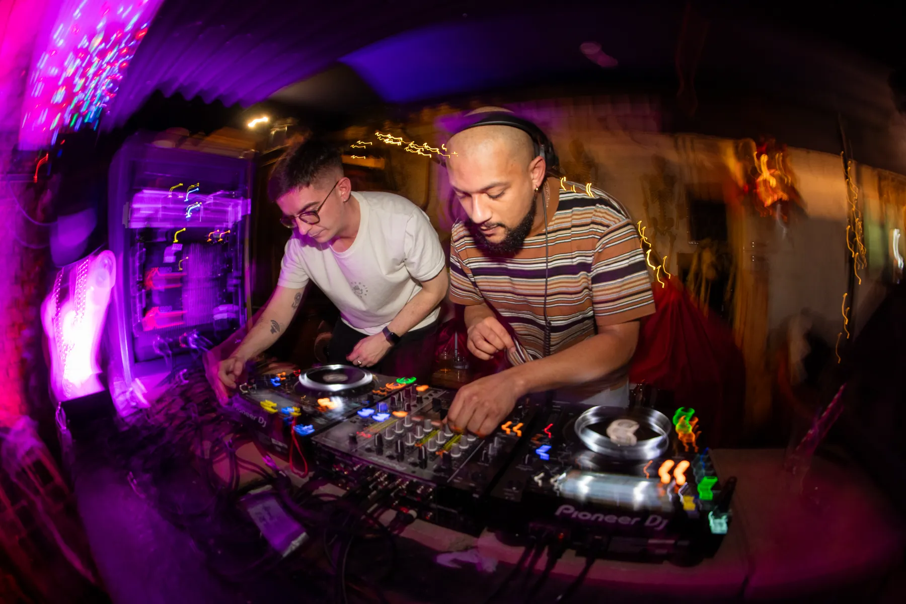 Close-up of two DJs working a packed booth at Love Shack